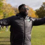 Micah Richards s úsmevom podpisuje zmluvu po boku manažéra Warley FC Lukea