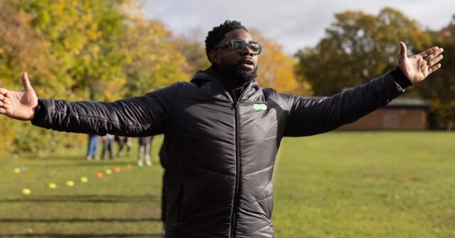 Micah Richards s úsmevom podpisuje zmluvu po boku manažéra Warley FC Lukea