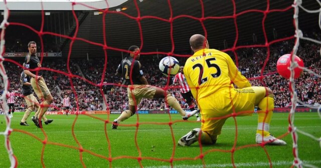 Darren Bent zo Sunderlandu počas zápasu Barclays Premier League medzi Sunderlandom a Liverpoolom sleduje, ako jeho strela smeruje medzi Glena Johnsona a Pepeho Reinu z Liverpoolu a do bránky.