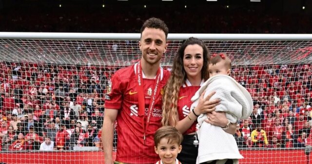 Mužský športovec v červenom drese triumfálne stojí so zdvihnutými rukami a zdanlivo oslavuje významný úspech na ihrisku. Pozadie je plné nadšeného davu, čo naznačuje dôležitosť okamihu.