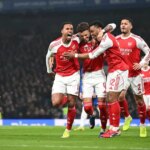 Ben White oslavuje strelenie prvého gólu Arsenalu s Bukayom Sakom, Gabrielom Magalhaesom a Jurrienom Timberom počas prvého zápasu semifinále Carabao Cupu medzi Chelsea a Arsenalom na Stamford Bridge.