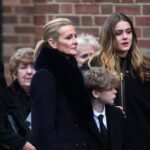 Gabby Logan a jej rodina v formálnom oblečení stoja pred tehlovou stenou na pohrebe Terryho Yoratha.