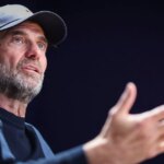 Jurgen Klopp s rozpaženými rukami v rozhovore