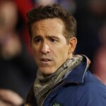 Spolumajiteľ Wrexhamu Ryan Reynolds sa prizerá z ihriska na Racecourse Ground