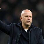 Marc Guehi a Virgil van Dijk si podávajú ruky, zatiaľ čo Alexis Mac Allister sa prizerá