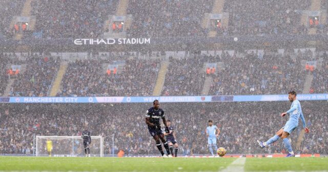 Ruben Dias prihráva loptu, keď padá sneh počas zápasu Premier League medzi Manchester City a West Ham United na Etihad Stadium. 