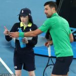 Novak Djokovič sa rozpráva s loptou počas zápasu na Australian Open. Chlapci a dievčatá nedostávajú za svoju prácu v Melbourne zaplatené