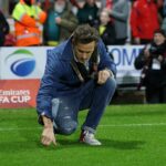 Ryan Reynolds zbiera trávu z ihriska Wrexham's Racecourse Ground