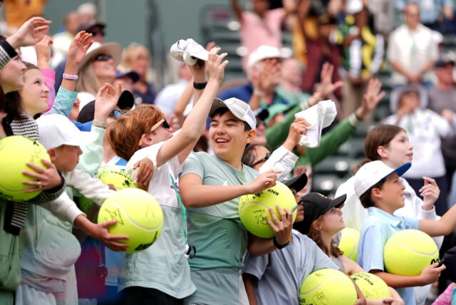 Tenisový fanúšik mávne rukou v nádeji na podpísanú loptičku od Madison Keys na štadióne 1 na turnaji BNP Paribas Open v Indian Wells v Kalifornii v stredu 12. marca 2025.