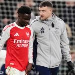 Bukayo Saka opúšťa ihrisko spolu so zdravotníckym personálom Arsenalu