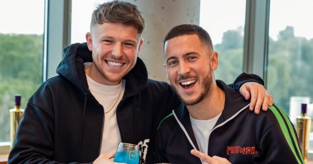 Eden Hazard pózuje na obrázku s Charliem Morganom, pričom obaja držia fľašu Au Vodky