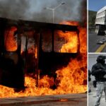 Vojak stojí na stráži pri spálenom vozidle