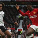 Kobbie Mainoo s loptou na kopačkách, keď Alex Iwobi vyvíja tlak