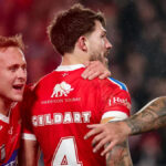 Reece Walsh (vpravo) sa vyhýba zásahu Mikeyho Lewisa (vľavo)