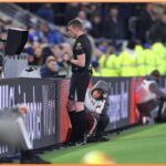 Rozhodca sa pozerá na VAR počas zápasu Premier League