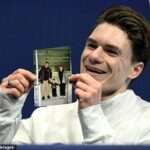 Maxim Naumov z USA drží fotku svojich zosnulých rodičov po svojom debute na zimných olympijských hrách