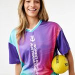 Austrálsky maloobchodný predajca Kmart bol opečený online po obrovskom škriepkaní, ktoré zahŕňalo Matildas pred Ázijským pohárom (na obrázku, model vo výstroji Matildas, pričom drží kopačku AFL Sherrin)