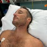 Závodná legenda Damien Oliver zdieľal tento obrázok z nemocnice po nehode pri surfovaní