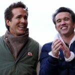 Ryan Reynolds, spolumajiteľ Wrexhamu, a Robert McElhenney, spolumajiteľ Wrexhamu, komunikujú pri prechádzke po ihrisku pred zápasom Sky Bet Championship medzi Wrexhamom AFC a Watfordom na Racecourse Ground 13. decembra 2025 vo Wrexhame vo Walese.