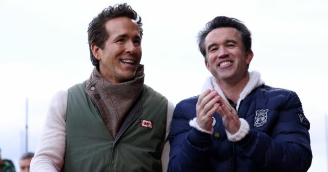 Ryan Reynolds, spolumajiteľ Wrexhamu, a Robert McElhenney, spolumajiteľ Wrexhamu, komunikujú pri prechádzke po ihrisku pred zápasom Sky Bet Championship medzi Wrexhamom AFC a Watfordom na Racecourse Ground 13. decembra 2025 vo Wrexhame vo Walese.