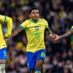 Casemiro z Brazílie (vľavo) a Bruno Guimarães z Brazílie (vpravo) pomáhajú Rodrygovi z Brazílie (C) počas medzinárodných priateľských stretnutí medzi Brazíliou a Senegalom na Emirates Stadium
