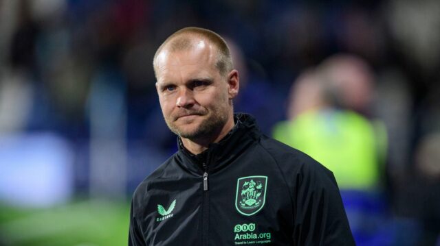 Liam Manning sa prizerá počas zápasu Huddersfield