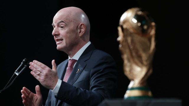 Vedľa FIFA World Cup Trophy stojí prezident FIFA Gianni Infantino