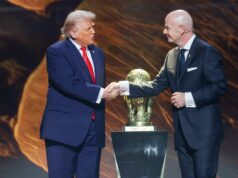 Každá krajina odstúpi z majstrovstiev sveta, pretože Irán zvažuje bojkot USA v roku 2026 Jednotlivec v spoločenskom oblečení, stojaci na tmavom pozadí a v ruke drží zlatú trofej.