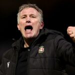 Phil Parkinson stojí vo výkope na Stamford Bridge a Jose Mourinho sa otáča, aby sa na neho pozrel