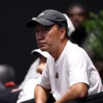 Študent Tien sa rozpráva s trénerom Michaelom Changom počas zápasu štvrtého kola proti Daniilovi Medvedevovi na Australian Open