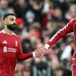 Francúzsky útočník Liverpoolu č. 22 Hugo Ekitike (R) si poklepal rukou s egyptským útočníkom Liverpoolu č. 11 Mohamedom Salahom, keď zišiel z lavičky, aby hral počas futbalového zápasu anglickej Premier League medzi Liverpoolom a Brightonom a Hove Albionom.