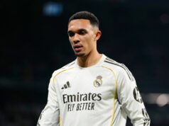 Thomas Tuchel vysvetľuje rozhodnutie Trenta Alexandra-Arnolda o vynechaní anglického tímu Jednotlivec oblečený v čiernej košeli s dlhým rukávom sa prihovára médiám na tlačovej konferencii. Na pozadí sú rôzne logá, vrátane Nike, Chase a ďalších.