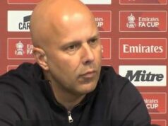 Arne Slot kritizuje mužstvo Liverpoolu a poukazuje na jeden faktor v ponížení Man City Jednotlivec s holou hlavou v čiernej mikine s kapucňou sedí na tlačovej konferencii a pozorne oslovuje zhromaždené médiá. Za ním kulisa ozdobená rôznymi sponzorskými logami vrátane