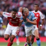 William Saliba z Arsenalu bojuje o držanie lopty s Erlingom Haalandom z Manchestru City