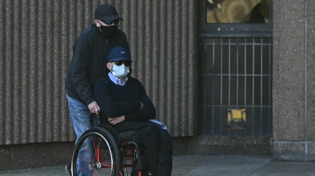 Mark Mogan, ktorý je obvinený z rasového zneužívania futbalistu Antoina Semenya počas zápasu v auguste 2025, je tlačený na invalidnom vozíku, keď prichádza na súdny proces na Liverpool Magistrates' Court v Liverpoole.