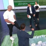 Na snímke: Skvelý kohút Boyd Cordner (vľavo) ukazuje Billymu Slaterovi (drží futbalovú loptu), že si roztrhol obrovskú dieru na nohaviciach v nedeľnej Footy Show Nine.