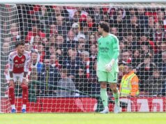 Hodnotenie hráčov Arsenalu vs Bournemouth: Šesť 4/10 zmizlo, pretože hviezda utrpela „najhorší zápas vôbec“ Dvaja jednotlivci oblečení v atletických uniformách sú postavení na futbalovom ihrisku, pričom jeden stojí za sieťou. Zdá sa, že pozorujú scénu zahŕňajúcu inú osobu, možno hráča, pred značným davom usadeným na tribúne. Celková atmosféra naznačuje intenzívny moment počas futbalového zápasu.