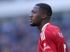 Ibrahima Konate potvrdzuje budúcnosť Liverpoolu po tom, čo bola obrana spojená s Realom Madrid Športovec v červenom športovom drese s číslom 18 stojí na ihrisku, možno počas futbalového zápasu, s rozmazaným davom v pozadí.