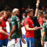 Paul Rutherford z Wrexhamu sa postaví proti Angelovi Balantovi z Dagenhamu a Redbridge počas zápasu Dagenham & Redbridge vs Wrexham v roku 2019