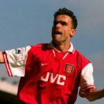 Muž oblečený v červeno-bielom futbalovom drese s