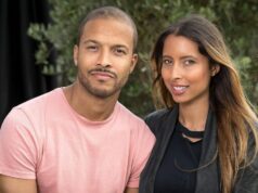 „Môj bývalý muž starlet z Man Utd zomrel pred 12 mesiacmi – teraz som tehotná s jeho dieťaťom“ Obrázok zobrazuje dospelého muža a ženu, ktorí stoja blízko pri sebe, usmievajú sa a pózujú pre fotografiu vo vonkajšom prostredí. Sú obklopené zeleňou a kulisou, ktorá naznačuje prostredie záhrady alebo parku. Samec je oblečený vo svetloružovom tričku, zatiaľ čo samica má oblečené sako tmavej farby cez čierny top.