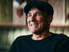 Aký je čistý majetok Vinnieho Jonesa? Vinnie Jones sa usmieva v čiernej mikine a plochej šiltovke