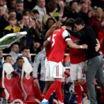 Myles Lewis-Skelly, Piero Hincapie a Viktor Gyoekeres z Arsenalu sa túlia s Mikelom Artetom, manažérom Arsenalu, keď sa pripravujú ako náhradníci počas zápasu Premier League medzi Arsenalom a Burnley na Emirates Stadium 18. mája 2026 v Londýne v Anglicku.