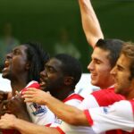 Matthieu Flamini v obleku s úsmevom a pózuje so skríženými rukami