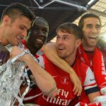 Mathieu Flamini v obleku sa usmieva a pózuje so skríženými rukami