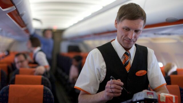 Letuška EasyJet obsluhuje cestujúcich počas letu z letiska London Southend na letisko El Prat v Barcelone, Španielsko, v pondelok 26. marca 2012. EasyJet Plc, druhá najväčšia európska zľavnená letecká spoločnosť, plánuje od budúceho mesiaca ponúkať cestujúcim pridelené miesta na sedenie v skúšobnej prevádzke, ktorá dopravcu posunie ďalej od jeho jednoduchého dedičstva.