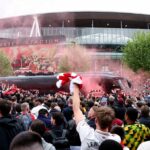 Fanúšikovia Arsenalu vítajú tímový autobus svetlicami a šálmi pred druhým semifinálovým futbalovým zápasom Ligy majstrov UEFA medzi Arsenalom a Atleticom Madrid na Emirates Stadium