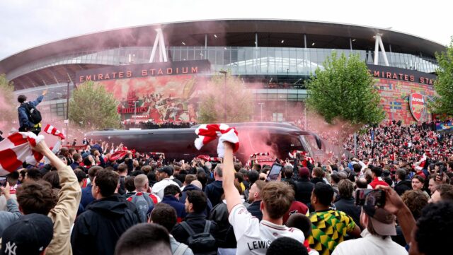 Fanúšikovia Arsenalu vítajú tímový autobus svetlicami a šálmi pred druhým semifinálovým futbalovým zápasom Ligy majstrov UEFA medzi Arsenalom a Atleticom Madrid na Emirates Stadium