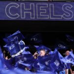 Logo/odznak FC Chelsea je vidieť na značke, keď fanúšikovia mávajú vlajkami počas semifinálového zápasu Emirates FA Cup medzi Chelsea a Leeds United