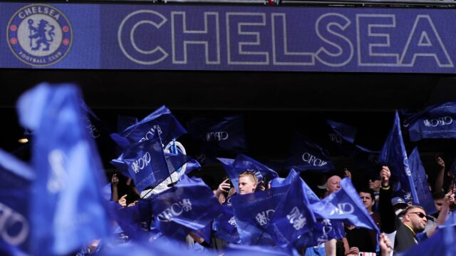 Logo/odznak FC Chelsea je vidieť na značke, keď fanúšikovia mávajú vlajkami počas semifinálového zápasu Emirates FA Cup medzi Chelsea a Leeds United 